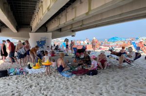 Read more about the article Upalny piątek w Kołobrzegu. Część plażowiczów szukała cienia i chłodu… pod molo