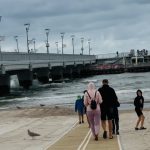widok na plaże i ludzi spacerujących w Kołobrzegu