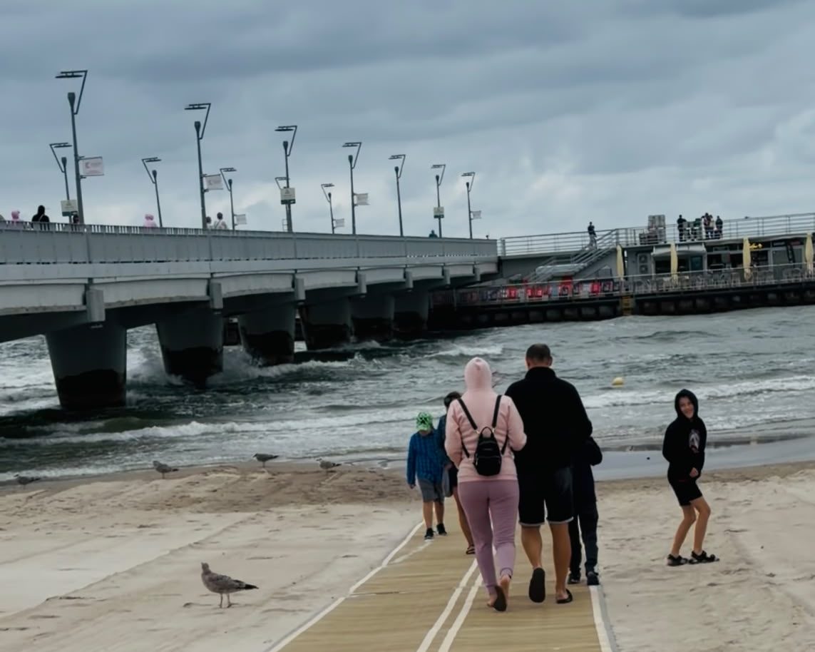widok na plaże i ludzi spacerujących w Kołobrzegu