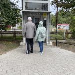 para seniorów stoi przed windą na kładkę kolejową w Kołobrzegu